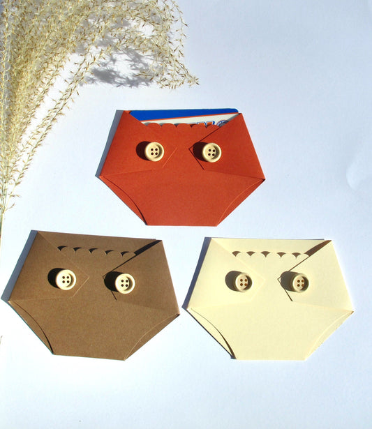 Three diaper-shaped gift card holders in brown, beige, and yellow colors, with wooden buttons and a pocket for holding a gift card.