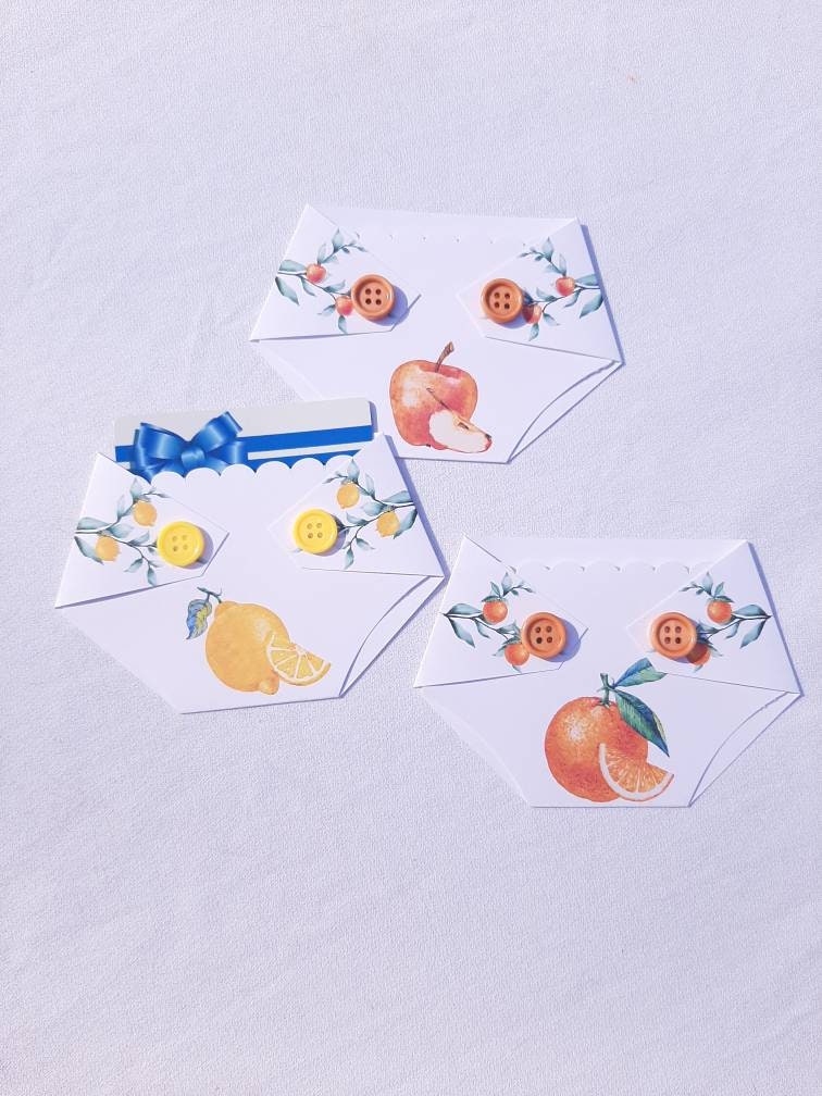 Diaper shaped Gift card holders with fruit designs and buttons, intended for use as baby shower game prizes or as a gift for mom to be.