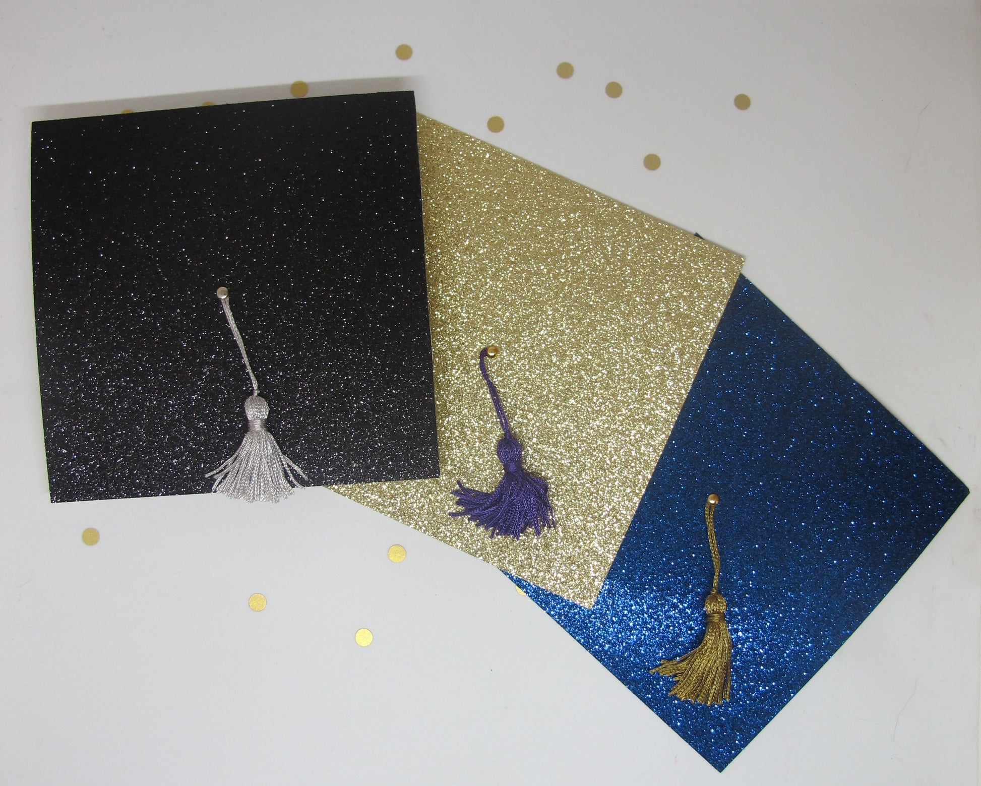 glitter graduation cap invitations in black, gold, and blue