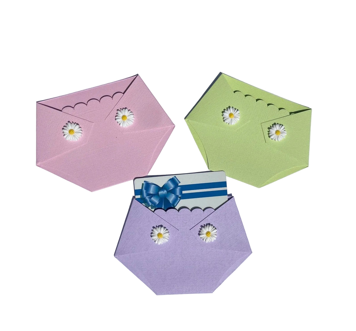 three diaper shaped gift card holders in pink, green, and purple with white daisies on the diaper flaps