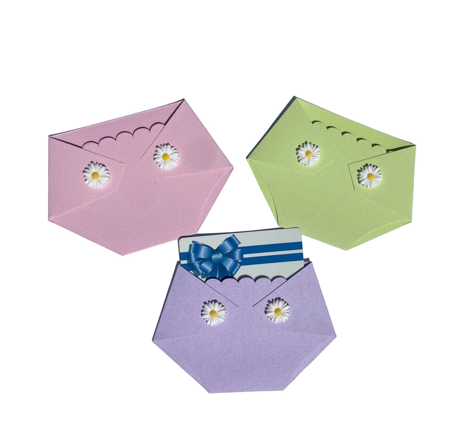 three diaper shaped gift card holders in pink, green, and purple with white daisies on the diaper flaps