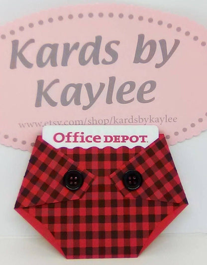 A plaid-patterned, diaper-shaped gift card holder with a red and black checkered design and black buttons, designed to hold a standard gift card.